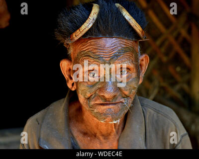 Indien à la retraite guerrier Naga Konyak et ex-chasseur de tête avec un tatouage facial tribal distinctif et chapeau de fourrure traditionnel pose pour la caméra. Banque D'Images