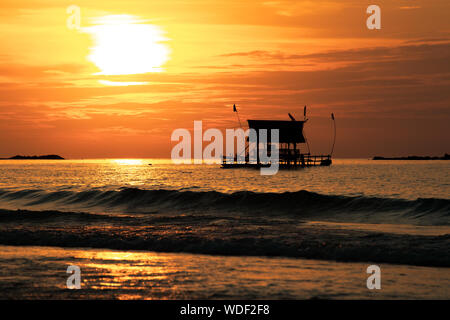 La silhouette du navire sur un fond de coucher du soleil doré. Le coucher du soleil, aux Philippines. Sur le bord de la mer. Banque D'Images