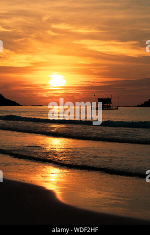 La silhouette du navire sur un fond de coucher du soleil doré. Le coucher du soleil, aux Philippines. Sur le bord de la mer. La verticale. Banque D'Images