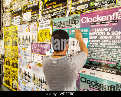 Hong Kong, Chine. Août 24, 2019. Un homme met en place une publicité d'un magasin pour la location ou la vente, à Causeway Bay de Hong Kong, Chine du sud, le 24 août, 2019. Hong Kong international favorable du droit et de l'environnement des affaires a été ternie comme violent et perturbateur des protestations ont commencé il y a plus de deux mois. La perturbation directe ou effets négatifs sur l'économie sont visibles dans la distribution, de la restauration et de l'industrie du tourisme, qui doivent recourir à des mises à pied au milieu de la forte diminution des ventes, nombre de clients et de revenus. Credit : Liu Dawei/Xinhua/Alamy Live News Banque D'Images