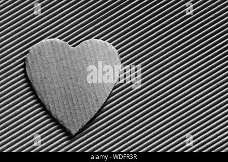 Valentine - symbole coeur taillé dans du carton ondulé. Copier l'espace. Espace libre pour texte, Close-up, vue du dessus. Photo en noir et blanc Banque D'Images