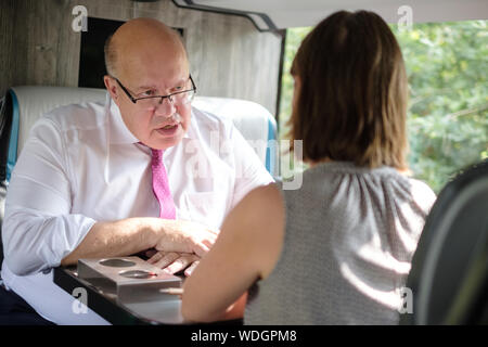 Bielefeld, Allemagne. Août 29, 2019. Peter Altmaier (CDU), Ministre fédéral de l'économie, parle à une journaliste dans un autocar. Altmaier visites moyennes entreprises en Basse Saxe et Rhénanie du Nord-Westphalie durant son voyage de trois jours, également d'envoyer un signal aux entreprises de taille moyenne. Il avait été fortement critiqué par des associations commerciales, en partie parce que les petites et moyennes entreprises n'a guère joué un rôle dans sa stratégie industrielle. Credit : Ole Spata/dpa/Alamy Live News Banque D'Images