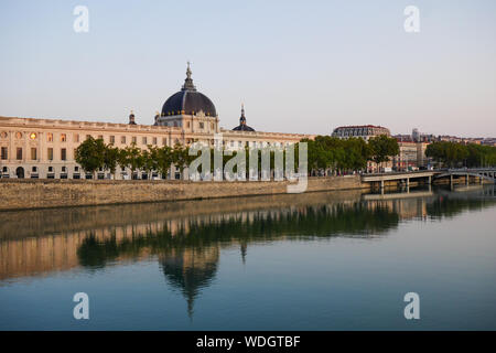 Façade du Grand Hôtel-Dieu se reflétant dans les eaux du Rhône au lever du soleil, Lyon, France Banque D'Images