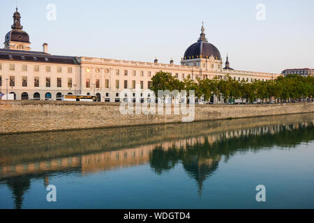 Façade du Grand Hôtel-Dieu se reflétant dans les eaux du Rhône au lever du soleil, Lyon, France Banque D'Images