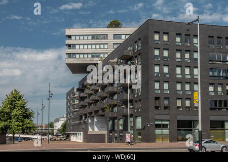 Amsterdam, Pays-Bas - 30 juin 2019 : l'architecture moderne immeuble de bureaux sur Westerdokplein a section avec des murs sombres et l'autre partie sur le dessus wi Banque D'Images