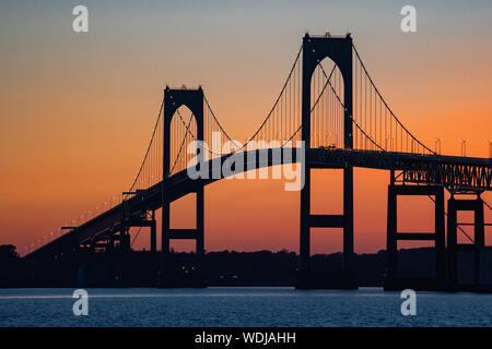 Silhouette du pont Claiborne Pell de Newport contre un ciel orangé au coucher du soleil sur la baie de Narragansett, Newport, Rhode Island, États-Unis. Banque D'Images