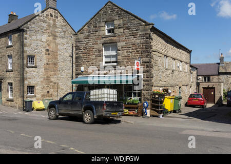 Scène de rue sur une journée d'été dans le village de Winster, Derbyshire, Royaume-Uni ; camion stationné à l'extérieur de l'épicerie du village et du bureau de poste Banque D'Images