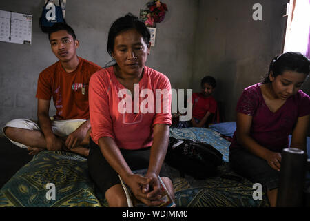 La Reforma, San Marcos, Guatemala. 9 Août, 2019. Huit jours après avoir été expulsés des États-Unis, LISARDO PEREZ se trouve par sa mère ELIDA ESPERANZA, sœur KARYN et frère Edgar GIOVANI, à leur maison dans le Canton La Palma quartier. Après 8 années de baisse des prix du café, et de 3 ans en regardant son jeune frère souffrent d'une maladie débilitante qui a laissé la famille dans la dette médicaux, ils mettent toute leur espérance en Lisardo prendre un prêt contre leur maison. Ils ont utilisé le prêt pour payer un passeur pour l'emmener vers les États-Unis qu'ils espéraient qu'il ferait assez d'argent pour les sauver. Après avoir traversé le Mexique et sp Banque D'Images