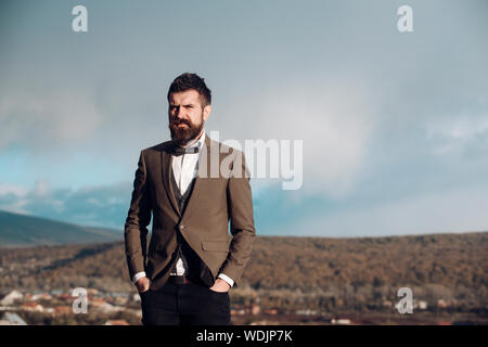 Homme avec barbe et moustache avec paysages de l'arrière-plan. Hipster avec élégance en face de ciel dramatique, d'horizon. Guy avec la lettre, en cla Banque D'Images