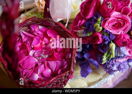Bouquet de mariage rose et violet . pour la diffusion des paniers de fleurs pétale de rose à une réception de mariage à l'église pour un service d'action de grâces. Pétales de rose Banque D'Images