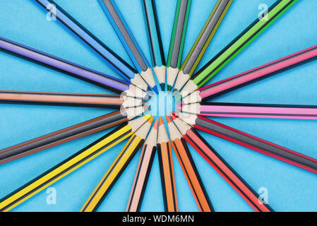 Cercle avec beaucoup de différents crayons de couleur sur un fond bleu Banque D'Images