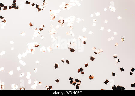 Argent chute confetti sur fond gris. Maison de concept. Banque D'Images