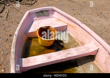 Grand, sale, à l'intérieur du godet en plastique jaune canot à fond plat contenant de l'eau dans elle, Brancaster Staithe, Norfolk, Angleterre Banque D'Images