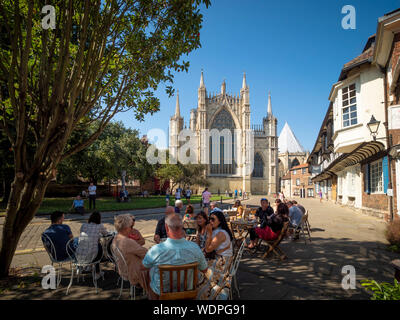 Les gens assis dehors au café avec York Minster et St Williams College en arrière-plan, la rue College, York, Royaume-Uni. Banque D'Images