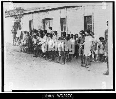 Les enfants réfugiés grecs et arméniens dans les casernes près d'Athènes, la Grèce a reçu 1 000 000 réfugiés, soit un à chaque famille du pays Résumé : Les enfants réfugiés grecs et arméniens d'Anatolie à l'extérieur un bâtiment d'un étage. Banque D'Images