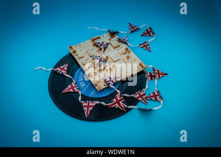 Vieux vinyle des célibataires records avec un ordinateur d'or et platine mini union jack bunting Banque D'Images