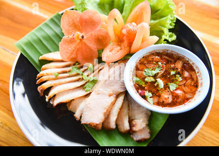 Tranches de rôti de porc porc / grillé avec sauce épicée et de riz collant fines herbes Épices légumes frais ingrédients servis sur plaque dans la table en bois Banque D'Images