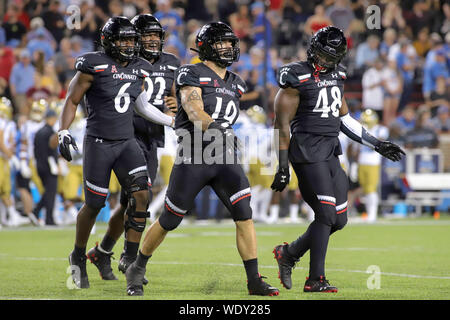 29 août 2019 - Cincinnati's Ethan Tucky (19) vérins pneumatiques pour célébrer son sac avec ses coéquipiers Perry Young (6) et Kevin Mouhon (48) au cours d'un match de football de la NCAA entre les Bearcats de Cincinnati et de l'UCLA Bruins à Nippert Stadium à Cincinnati, Ohio. Kevin Schultz/CSM Banque D'Images