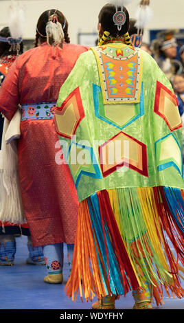 Deux femmes amérindiennes danser lors d'un pow-wow, photographié par derrière. L'un porte un châle avec frange ruban coloré. Banque D'Images