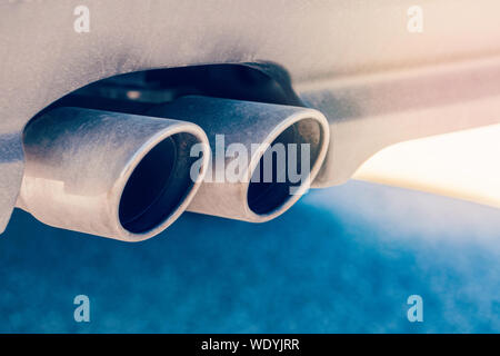 Macro closeup de double tuyau d'échappement. Détail de l'extérieur de voiture bleu élégant. Fuite de lumière et Sun flare copyspace pour le texte. Banque D'Images