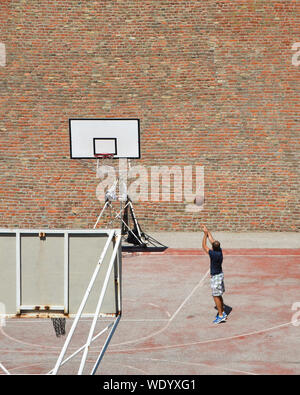 Streetball mâles adultes jouer en plein air sur la formation de basket-ball. Banque D'Images