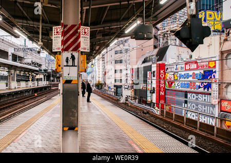 DEC 5, 2018 Tokyo, Japon - japonais local quelques passagers attendant JR Chuo line train station Kanda approching plate-forme surélevée. Banque D'Images