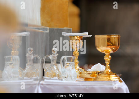 Calice sur l'autel d'or et d'ampoules avec du vin et de l'eau avant de la masse Banque D'Images