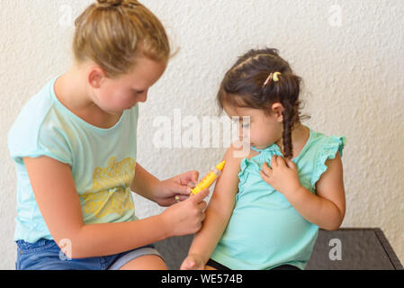 Enfants jouant médecin. La vaccination contre la grippe par injection médecin bras en petit enfant fille, en bonne santé et médical concept. Banque D'Images