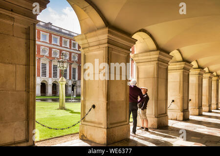 9 juin 2016 : Hampton Court, Richmond, London, UK - La Colonnade dans le Fountain Court, deux touristes masculins de visites. Le palais a été commencé à bâtir dans 15 Banque D'Images