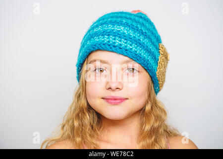 Différence entre le tricot et crochet. Modèles de tricot gratuit. Saison Automne Hiver accessoire. Chapeaux tricotés pour enfants. Des cheveux longs de fille heureux face fond blanc. Usure Kid blue hat tricoté doux chaleureux. Banque D'Images