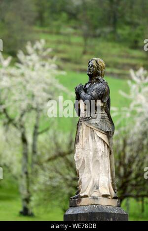 France, Doubs, Mouthier Haute Pierre, parvis de l'église Saint Laurent, en date du 15e siècle, statue de Jeanne d Arc, vergers, fleurs de cerisier en avril Banque D'Images