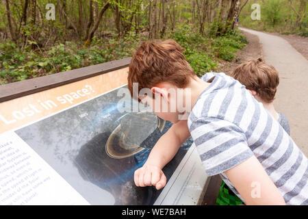 Un garçon à la lecture et à un conseil sur le système solaire à Ruislip Lido, Grand Londres Banque D'Images