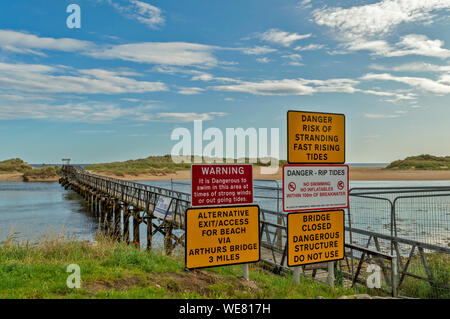 LOSSIEMOUTH CÔTE DE MORAY ECOSSE INSTABLE LE PONT DE LA RIVIÈRE LOSSIE PLAGE À L'EST ET DES PANNEAUX D'AVERTISSEMENT Banque D'Images