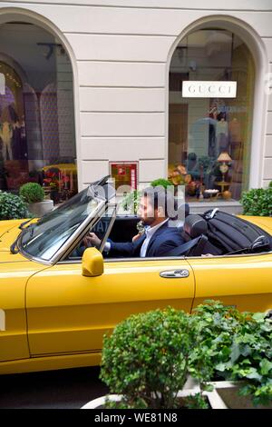 L'Italie, Lombardie, Milan, Quadrilateral (quadrilatero della moda), Alfa Romeo Spider Duetto cabriolet jaune en face de la boutique de luxe Gucci via Santo Spirito Banque D'Images