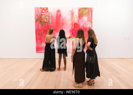 Les femmes de l'art, vue arrière de quatre jeunes femmes à la recherche lors d'une peinture de Jennifer Packer (une leçon dans désir), Whitney Museum of American Art, New York City Banque D'Images