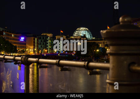 Berlin, Allemagne - 25 août 2019 - Bundestag, siège du parlement, avec pont et une barrière floue au premier plan dans la nuit Banque D'Images