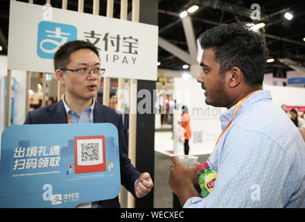 (190830) -- SYDNEY, 30 août 2019 (Xinhua) -- Un membre du personnel de l'exposant présente Alipay à un visiteur au cours de l'E-Commerce Alibaba Expo à Sydney, Australie, 30 août 2019. L'E-Commerce Alibaba Expo a commencé à Sydney le vendredi, de l'administration d'Australian and New Zealand brands l'occasion d'accéder à la base de clients en ligne toujours croissante. (Xinhua/Bai Xuefei) Banque D'Images