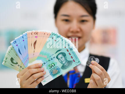 (190830) -- BEIJING, 30 août 2019 (Xinhua) -- un membre du personnel affiche les billets et les pièces incluses dans l'édition 2019 de la cinquième série du renminbi à un Wood et commerciale de Chine (ICBC) succursale à Beijing, capitale de la Chine, 30 août 2019. Une nouvelle édition de la cinquième série de la monnaie chinoise, le renminbi ou le yuan, a été officiellement lancé vendredi avec des couleurs plus claires et plus sophistiquées caractéristiques anticontrefaçon. La cinquième série de renminbi a été introduit en 1999. (Xinhua/Chen Yehua) Banque D'Images