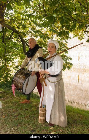 La reconstitution médiévale musiciens en costume de jouer des cornemuses de drones et un tambour à Beaumaris Castle dans le Nord du Pays de Galles Banque D'Images