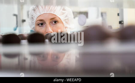 30 août 2019, la Saxe-Anhalt, Halle (Saale) : Un employé vérifie la qualité de l'enrobage de chocolat de chocolat et praliné spécialités régionales au cours de la production à Halloren Schokoladenfabrik AG de Halle. L'Assemblée Générale Annuelle Halloren Schokoladenfabrik AG est actuellement en cours au siège de la société. Photo : Peter Endig/dpa-Zentralbild/dpa Banque D'Images