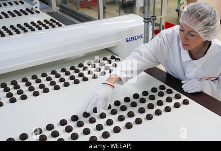 30 août 2019, la Saxe-Anhalt, Halle (Saale) : Un employé vérifie la qualité de l'enrobage de chocolat de chocolat et praliné spécialités régionales au cours de la production à Halloren Schokoladenfabrik AG de Halle. L'Assemblée Générale Annuelle Halloren Schokoladenfabrik AG est actuellement en cours au siège de la société. Photo : Peter Endig/dpa-Zentralbild/dpa Banque D'Images