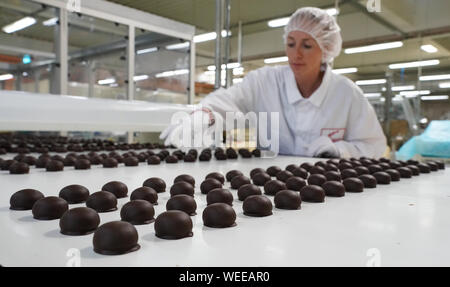 30 août 2019, la Saxe-Anhalt, Halle (Saale) : Un employé vérifie la qualité de l'enrobage de chocolat de chocolat et praliné spécialités régionales au cours de la production à Halloren Schokoladenfabrik AG de Halle. L'Assemblée Générale Annuelle Halloren Schokoladenfabrik AG est actuellement en cours au siège de la société. Photo : Peter Endig/dpa-Zentralbild/dpa Banque D'Images