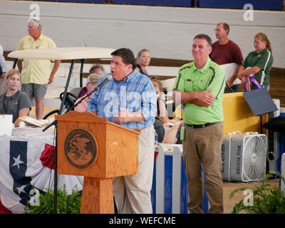 Springfield, Illinois, USA. 13 août 2019. Gouverneur JB Pritzker lors de la Foire de l'état de l'Illinois 2019 Vente du gouverneur de Champions. Ministère de l'Agriculture Directeur John Sullivan en chemise verte. Banque D'Images