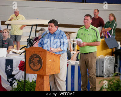 Springfield, Illinois, USA. 13 août 2019. Gouverneur JB Pritzker lors de la Foire de l'état de l'Illinois 2019 Vente du gouverneur de Champions. Ministère de l'Agriculture Directeur John Sullivan en chemise verte. Banque D'Images