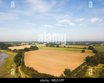 Vue aérienne de la campagne du Suffolk avec un champ de foin récolté récemment au premier plan Banque D'Images