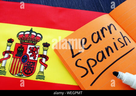 Apprendre l'espagnol écrit dans l'ordinateur portable avec drapeau. Banque D'Images