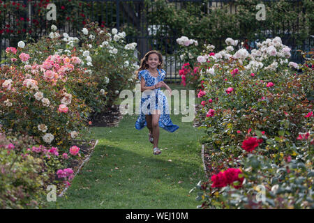 Preteen girl d'apparence asiatique faisant la gymnastique au rose garden, San Jose, Californie Banque D'Images