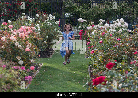 Preteen girl d'apparence asiatique faisant la gymnastique au rose garden, San Jose, Californie Banque D'Images