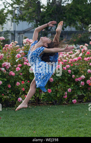 Preteen girl d'apparence asiatique faisant la gymnastique au rose garden, San Jose, Californie Banque D'Images