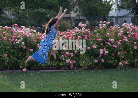 Preteen girl d'apparence asiatique faisant la gymnastique au rose garden, San Jose, Californie Banque D'Images